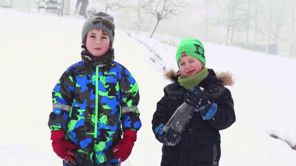 Josef und Elias mit ihrer Bobbahn im Schnee.