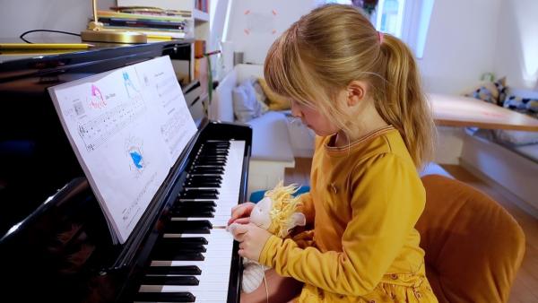 Ida spielt mit ihrem Kuscheltier Klavier.