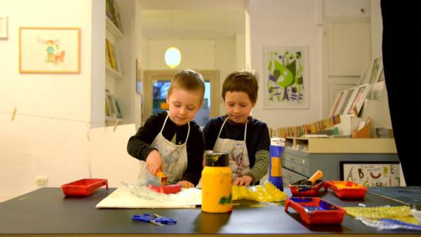 David und Max bemalen Luftpolsterfolie mit Farbe.