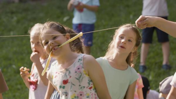 Kindergartenkinder spielen Schlangenessen.