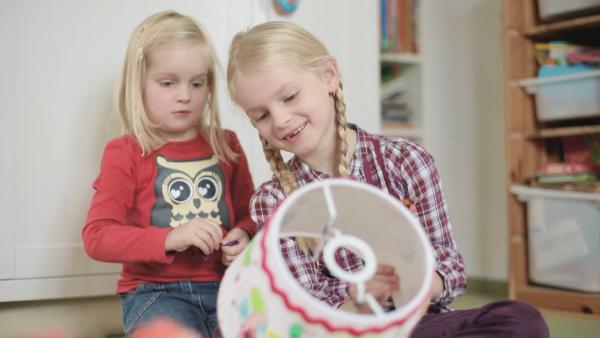 Pauline und Greta basteln einen Lampenschirm.