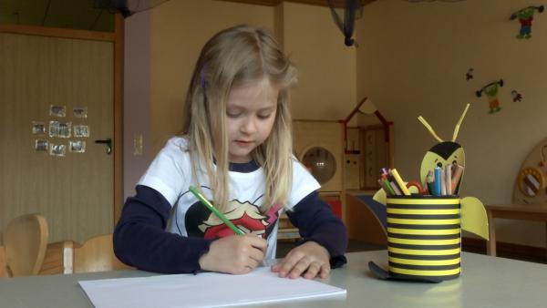 Astrid malt mit Buntstiften.