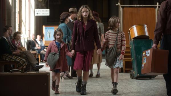 Fanny (Léonie Souchaud, Mitte) steckt mit ihren Schwestern Georgette (Juliane Lepoureau, links) und Erika (Fantine Harduin, rechts) auf dem Bahnhof in Annecy fest.