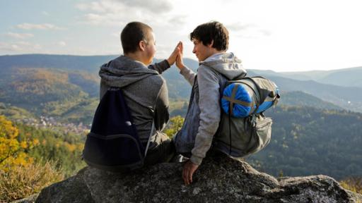 Zwei Jungen sitzen auf einem Felsen und klatschen sich ab | Rechte: SWR Zwei Jungen sitzen auf einem Felsen und klatschen sich ab
