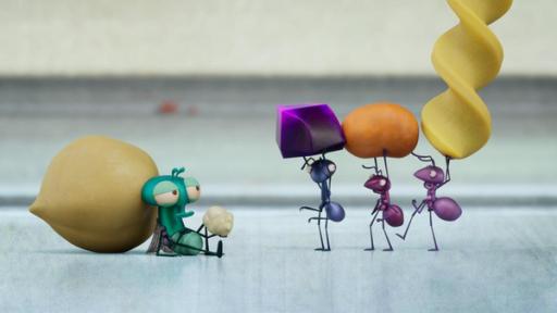 Arbeiten wie eine Ameise | Rechte: ©Aardman Animations 2022 Auf dem grauen Steinfußboden der Küche sitzt Floyd erschöpft an eine Kichererbse gelehnt. In seiner Hand hält er einen Krümel und schaut zu drei Ameisen, die hintereinander aufgereiht direkt vor ihm stehen und jeweils etwas Essbares tragen.