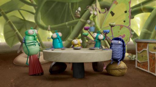 Ein Menü zum Fürchten | Rechte: ©Aardman Animations 2022 Vor Blättern und Stängeln einer Grünpflanze sitzt Floyd mit Abakus und seiner Familie an einem runden Tisch. Hinter ihnen steht Cornea, mit vier Schälchen in ihren Händen. Cornea schaut interessiert zu ihren Gästen herunter und die schauen skeptisch zu ihr auf.