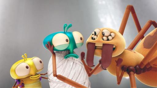 Spinnen fressen keine Fliegen, oder? | Rechte: ©Aardman Animations 2022 Vor einem grauen Hintergrund stehen PB und Floyd der Spinne Julie direkt gegenüber. Floyd ist bis zum Kopf in Spinnfäden eingewickelt und schaut mit großen Augen ängstlich in Julies acht Augen. Julie hält mit einem ihrer Füße Floyds Kopf. PB versteckt sich hinter Floyd, guckt aber neugierig.