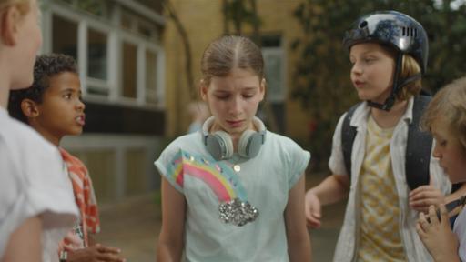 Eileen ist umringt von vier Kindern aus ihrer Schule. Sie schaut unglücklich, denn das ist ihr zu viel.