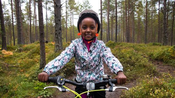 Mutig fährt Paola auf ihrem Mountainbike den Berg herunter.