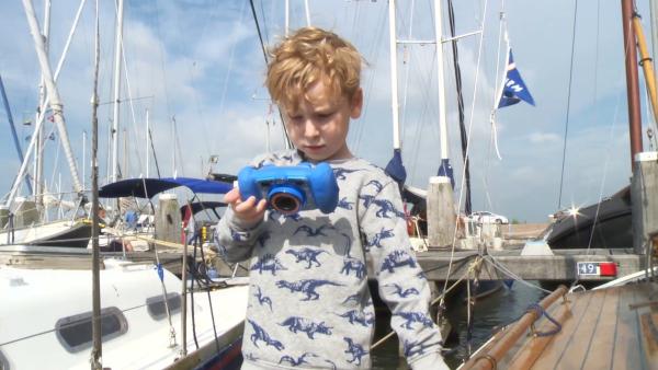 Wybe möchte mit seinem Opa und seinem Vater segeln gehen.Bevor es losgeht, zeigt er uns selbst mit seiner Kamera das Segelboot.