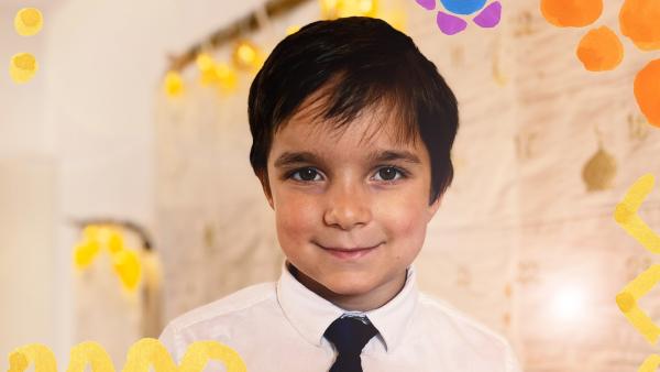 Yunus hat sich festlich mit Hemd und Krawatte angezogen. Er freut sich auf das Fest, denn er möchte dazu auch ein Theaterstück aufführen.
