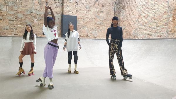Oumi (2.v.l.) lädt Jess zu einem Workshop ein und bringt ihr ein paar coole Moves auf Rollerskates bei.