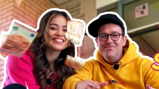 Im Hintergrund ist ein Eingang einer Schule zu sehen. Davor hocken Sarah und Ben. Vor ihnen fliegen mehrere Euro-Scheine durch die Luft. Rechts steht in gelber Schrift "Schlau=Scheine". Dabei ist das erste E bei Scheine ein Eurozeichen.