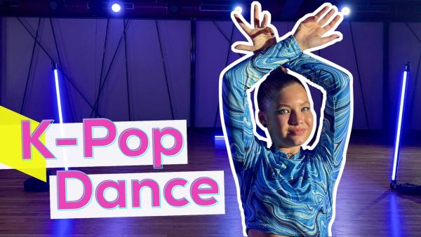 Auf der rechten Seite steht Beatrice. Sie überkreuzt die Hände über dem Kopf und lächelt. Im Hintergrund eine Tanzfläche mit Leuchtröhren. Links in pinker Schrift K-Pop Dance.