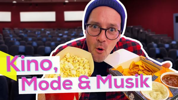 Ben mit überraschtem Gesichtsausdruck vor einem leeren Kinosaal. Er hält in einer Hand eine Tüte Popcorn, in der anderen eine Schale Nachos mit Dips. Unten die Aufschrift: Kino, Mode & Musik.