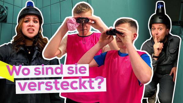 In der Mitte zwei Schüler. Jeder hält mit beiden Händen ein Fernglas vor sich und schaut hindurch. Links ist Sarah in ihrem Versteck, Ben rechts in seinem. Aufschrift unten links: Wo sind sie versteckt?