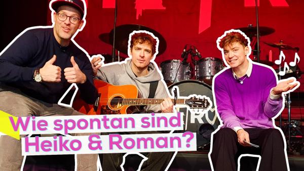 Ben sitzt, gut gelaunt, mit Heiko und Roman auf der vorderen Kante der Bühne. Im Hintergrund ein Schlagzeug und das Bühnen-Set. Aufschrift links: Wie spontan sind Heiko und Roman?