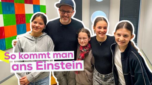 Ben steht mit vier Kandidatinnen des Schloss Einstein Castings eng nebeneinander. Im Hintergrund ein Flur des Sets. Aufschrift: So kommt man ans Einstein.