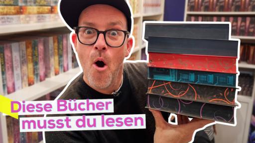 Ben mit erstauntem Gesichtsausdruck und einem Stapel Bücher in den Händen. Im Hintergrund große, gefüllte Bücherregale. Aufschrift: Diese Bücher musst du lesen.