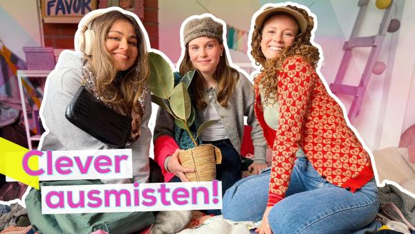 Sarah, Lulu und Aufräum-Expertin Mara sitzen auf dem Boden in einem wilden Haufen von Klamotten, Deko und Accessoires. Hintergrund Lulus Zimmer. Aufschrift: Clever ausmisten.