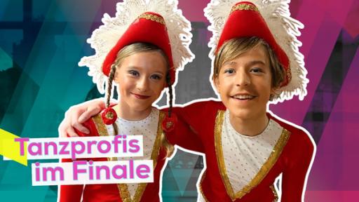Daria und Denny stehen gute gelaunt eng nebeneinander. Beide tragen rote Garde-Outfits. Aufschrift: Tanzprofis im Finale.