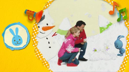Kikaninchen, Anni und Christian betrachten die ersten Frühblüher, die aus einem Schneehäufchen hervorschauen. Im Hintergrund ein Schneemann.