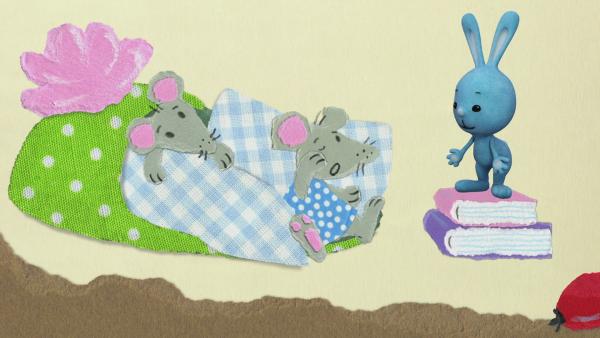Kikaninchen und zwei Mäusekinder in einem Pantoffelbett
