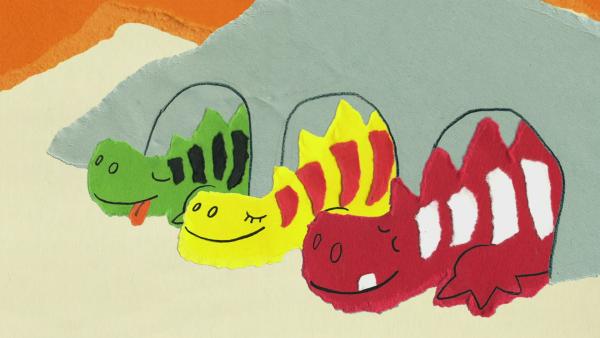 Drei schlafende bunte Drachen schauen aus einer Höhle.