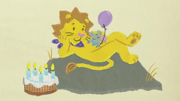 Ein Löwe und eine Maus, die auf seinem Bauch sitzt mit einem Luftballon 