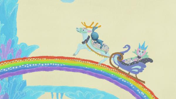 Kikaninchen und die Schneekönigin fahren mit einem Rentierschlitten über den Regenbogen.