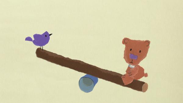 Ein Vogel und ein Teddybär wippen gemeinsam.