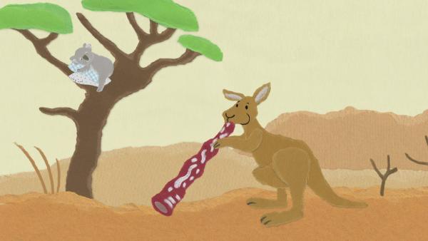 Ein Känguru spielt auf einem roten Didgeridoo.