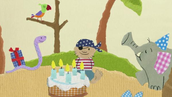 Schlange, Elefant und Pirat stehen vor einer Geburtstagstorte.