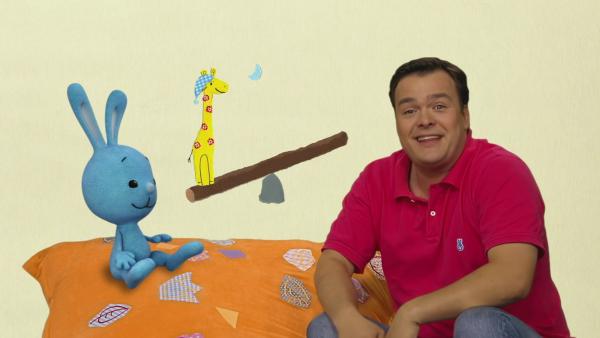 Kikaninchen und Christian sehen einer Giraffe beim Wippen zu