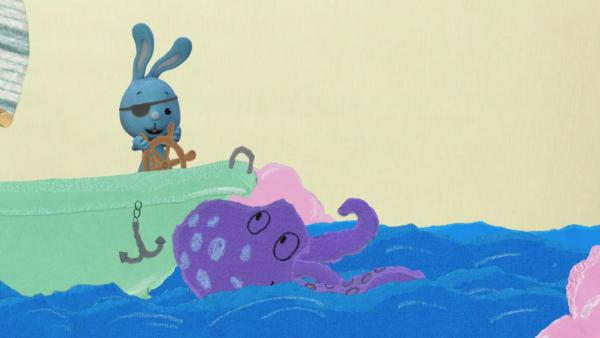 KiKANiNCHEN steuert als Pirat eine Badewanne auf dem Meer, daneben ein Oktopus.