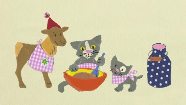 Tonki das Rentier und zwei kleine Kätzchen stehen um eine Schüssel. 