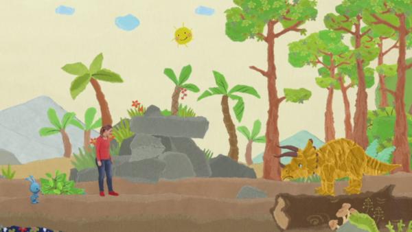 Anni und Kikaninchen begegnen im Wald eimem Dinosaurier.