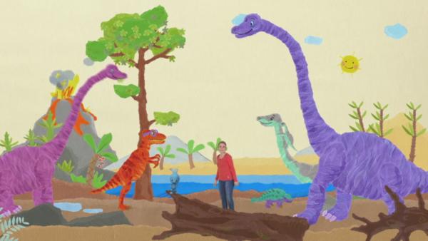 KiKANiNCHEN und Anni mit einem T-Rex umringt von anderen Dinos