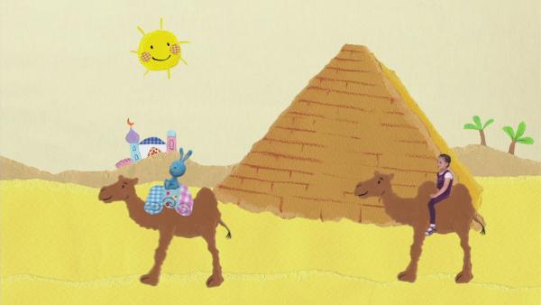 Kikaninchen reitet auf einem Kamel durch die Wüste