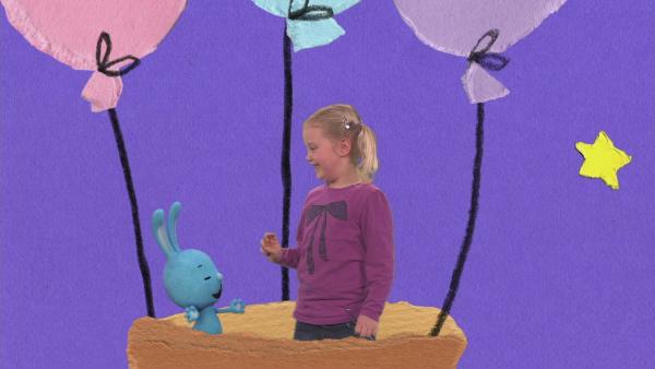 Kikaninchen und ein kleines Mädchen stehen in einem Ballonkorb.