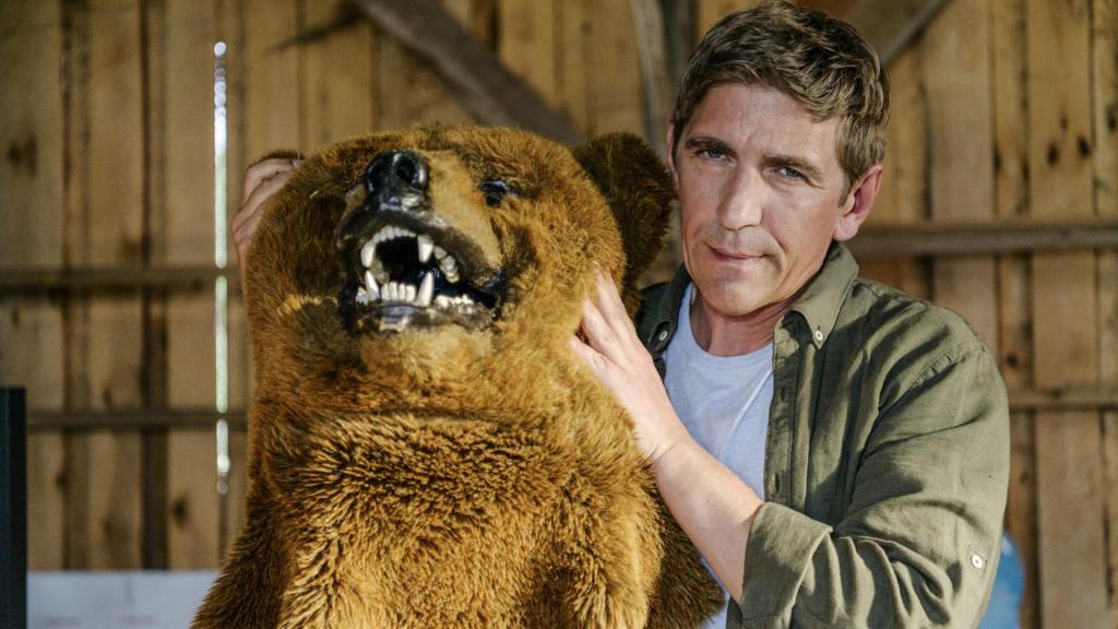 Fritz Fuchs hält das Oberteil eines Bärenkostüms mit Bärenkopf in den Händen