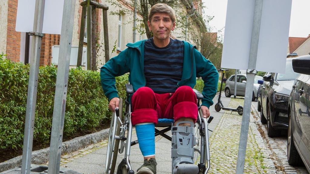 Fritz Fuchs sitzt im Rollstuhl auf einem Gehweg