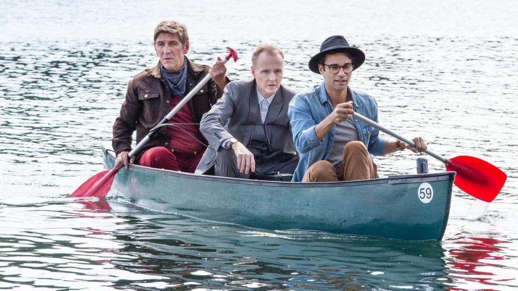 Fritz paddelt mit Kluthe und Joseph “Flying Bear” Hawkings in einem Kanu über einen See