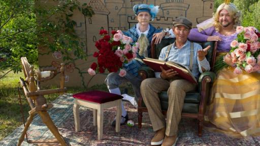 Fritz, David Paschulke und Heinz Kluthe sitzen verkleidet wie im Märchen Dornröschen vor einem Pappaufsteller, auf dem eine Burg gemalt ist.
