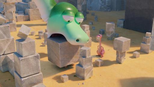 Minus Drei, der rosafarbene Dinosaurier, steht neben vielen Steinblöcken. Er schaut zu, wie ein grüner, gigantisch großer Dinosaurier mit dem Mund einen Steinblock wie ein Bagger hoch hieven möchte.