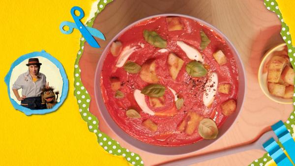 Selbstgemachte Tomatensuppe aus dem Backofen in einer tiefen Schüssel.  Daneben sind Moppi und Maya zu sehen.