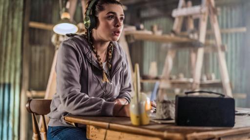 Geheime Verabredung | Rechte: ZDF Natasha sitzt konzentriert zuhörend mit Kopfhörern auf den Ohren und einem Babyphone an einem Tisch und belauscht ein Gespräch.