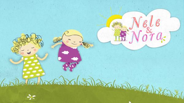 Nele und Nora hüpfen fröhlich auf einer Wiese herum.