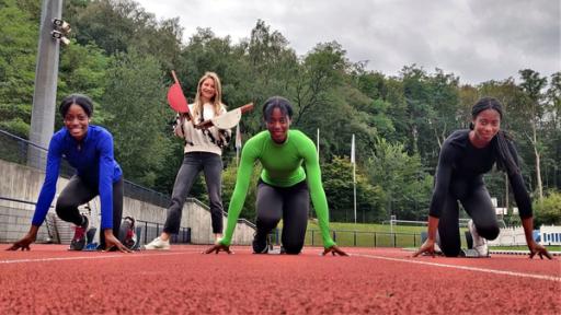 Im Dreierpack - Dörte, Dorinda und Dorina sind Drillinge | Rechte: WDR | tvision Die Drillinge Dörte, Dorina und Dorinda in Startposition auf dem Sportplatz. Hinter ihnen schlägt Jana die Start-Klappe.
