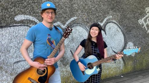 Robert und Sarah Hübers haben ihre Gitarren umgeschnallt, um gemeinsam Straßenmusik zu machen.